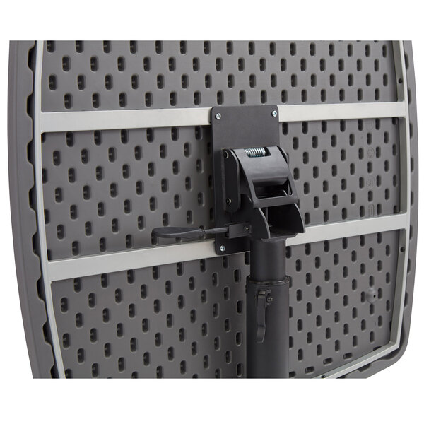 A black National Public Seating mobile table with a black handle on a metal surface.