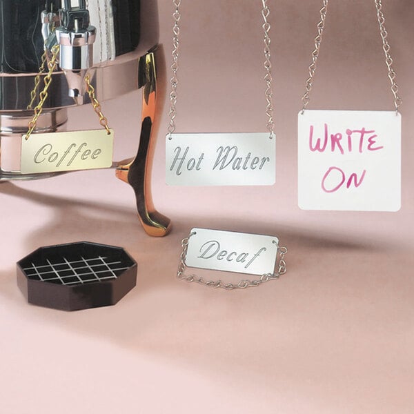 A Cal-Mil silver chain sign that says "Decaf" hanging from a coffee machine.