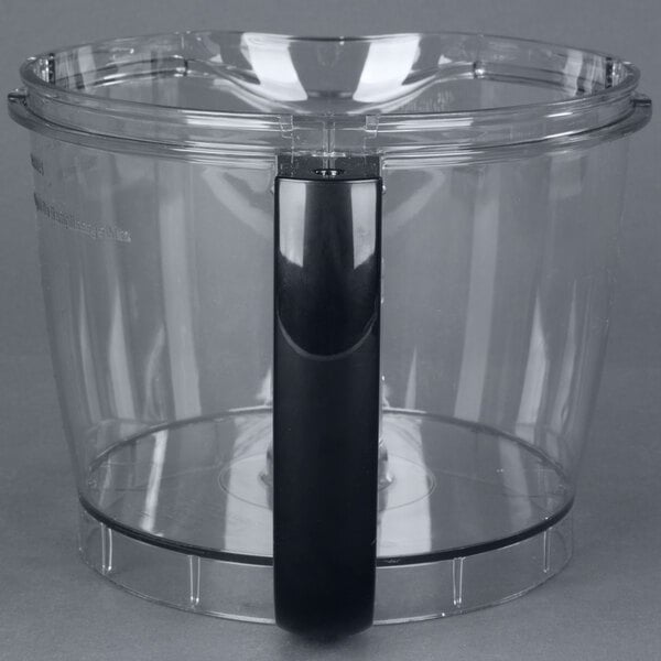A clear plastic container with a black handle.