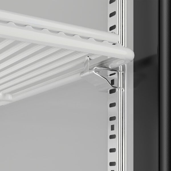 A close-up of a shelf with a metal bracket inside a Beverage-Air Marketeer Series glass door refrigerator.