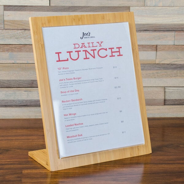 A Cal-Mil bamboo menu displayette with a menu on a wood stand.