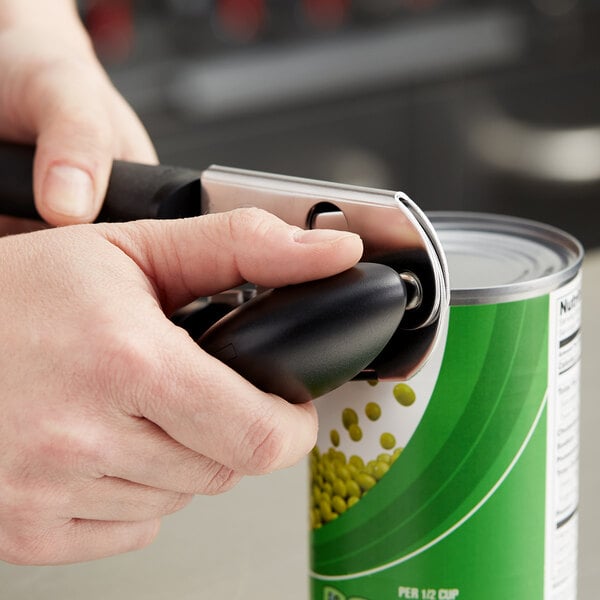 A hand using the OXO Good Grips can opener to open a can.