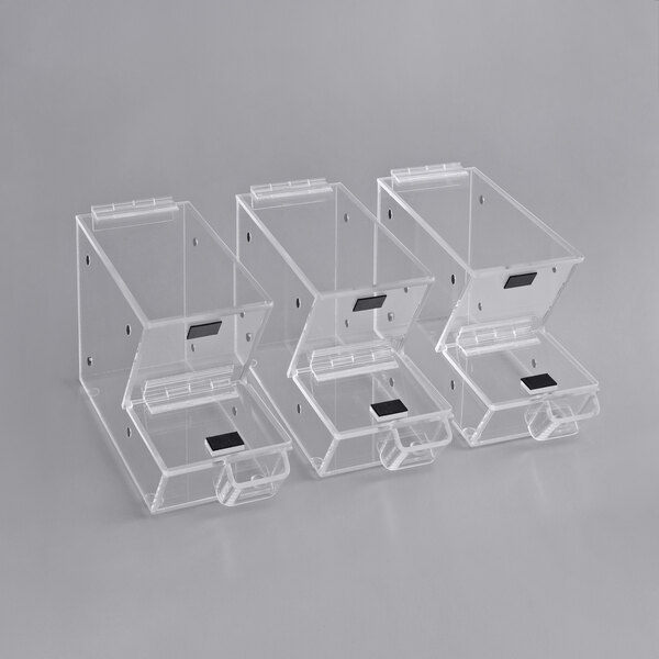 Three clear plastic stackable candy and topping dispensers with black rectangular scoop holsters.