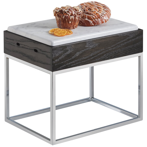 A Cal-Mil Cinderwood marble riser with a table holding two muffins.