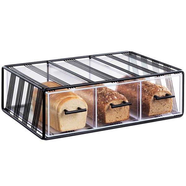 A black Cal-Mil bread display case with three drawers holding loaves of bread.