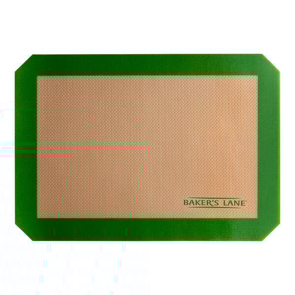 A tan rectangular Baker's Lane silicone baking mat with a green border.