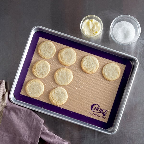 A tray of cookies on a Choice purple silicone non-stick baking mat.