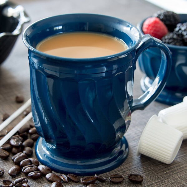 A close-up of a blue Dinex Turnbury insulated mug with a drink in it.