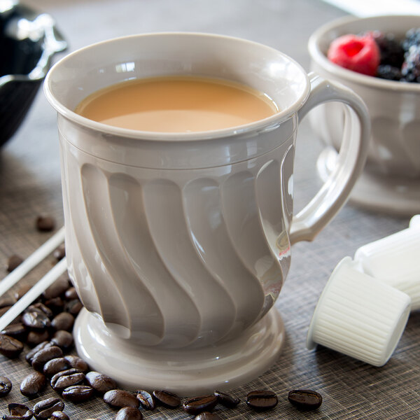 A Dinex Turnbury insulated latte mug filled with a drink on a table.