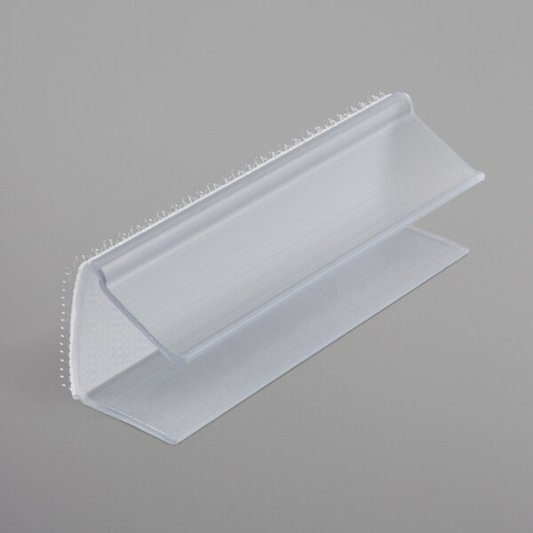 A clear plastic Snap Drape table skirt clip with a hook and loop attachment.