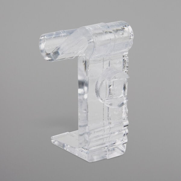 A clear plastic Snap Drape C skirt clip with a round circle and a hole in it.