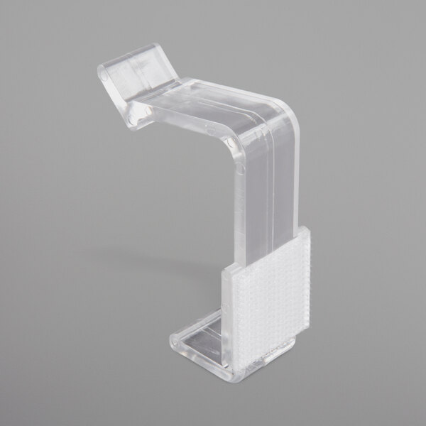 A clear plastic Snap Drape table skirt clip with a white hook and loop attachment.