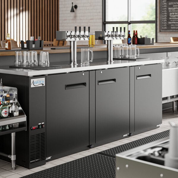 An Avantco UDD-4-HC kegerator with four taps on a bar counter.