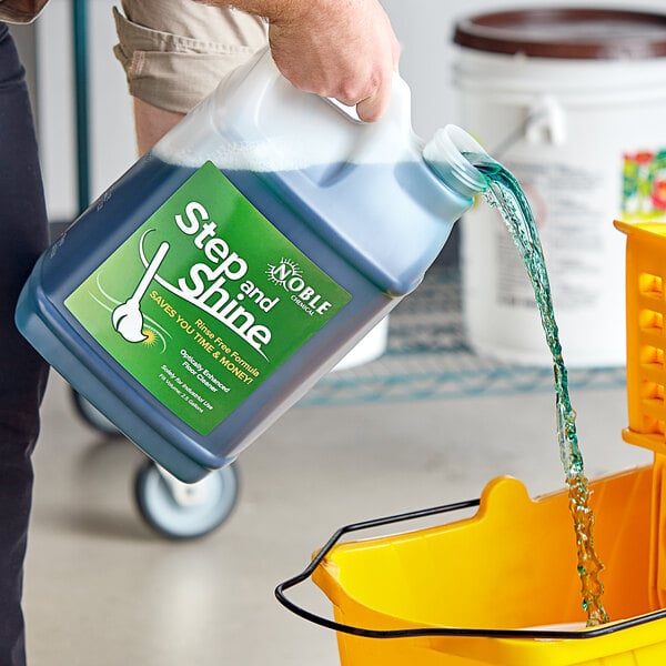 A person pouring Noble Chemical Step & Shine floor cleaner into a bucket.