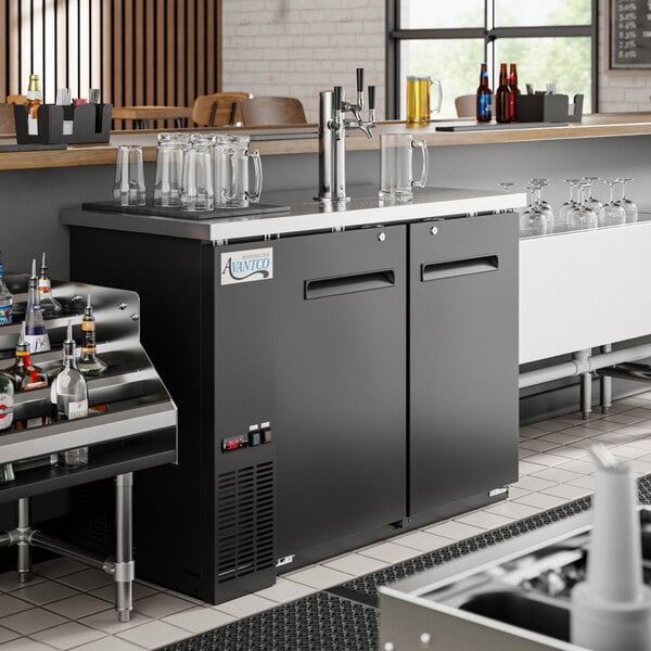 An Avantco triple tap kegerator on a bar counter with beer taps.