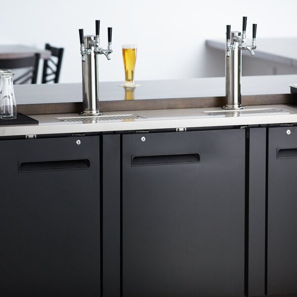 An Avantco black beer dispenser with two taps on a counter.