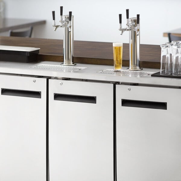 An Avantco stainless steel beer dispenser on a counter with two taps.