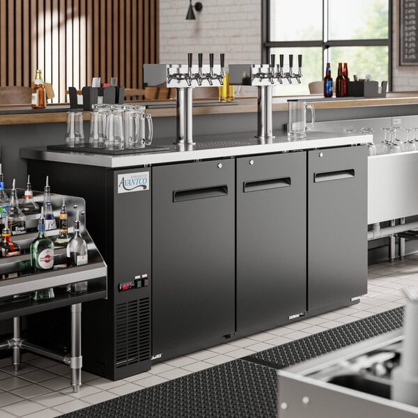 An Avantco UDD-72-HC Shallow Depth Kegerator with four beer taps on a counter in a bar.