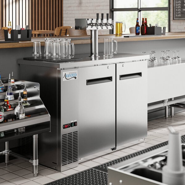 An Avantco stainless steel beer dispenser with two taps on a counter.