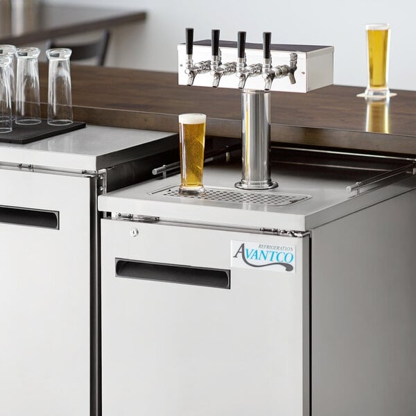 An Avantco stainless steel beer dispenser on a counter with two glasses on it.