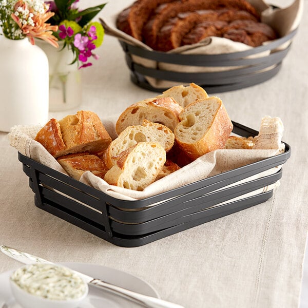 A rectangular metal gray wire basket filled with sliced bread on a table.