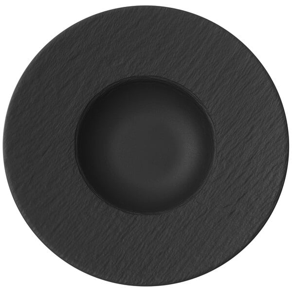 A black porcelain plate with a round center and a black circle in the surface.