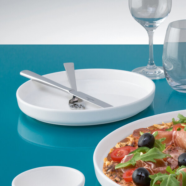 A Villeroy & Boch white porcelain platter with food and a knife on it.