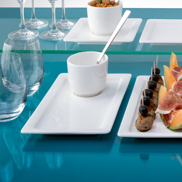 A white rectangular porcelain plate with food on a table.