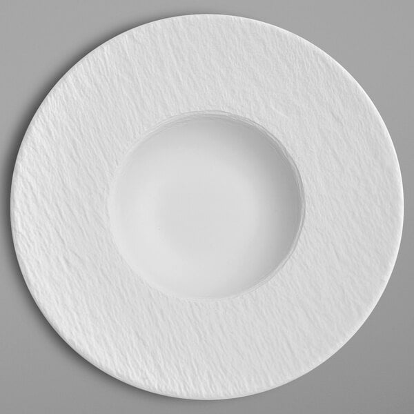 A white porcelain plate with a round center and a circular rim.