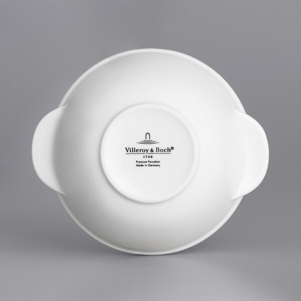 A white round porcelain bowl with two handles.