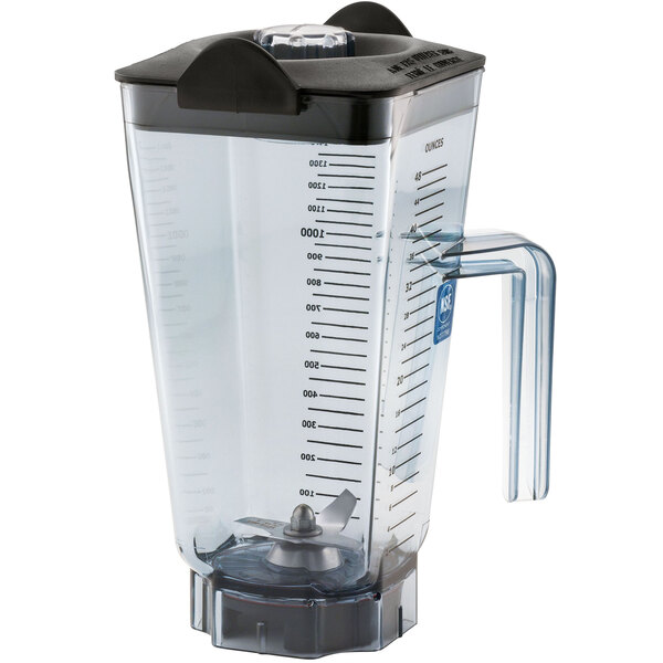 A clear plastic Vitamix blender jar with a black handle.