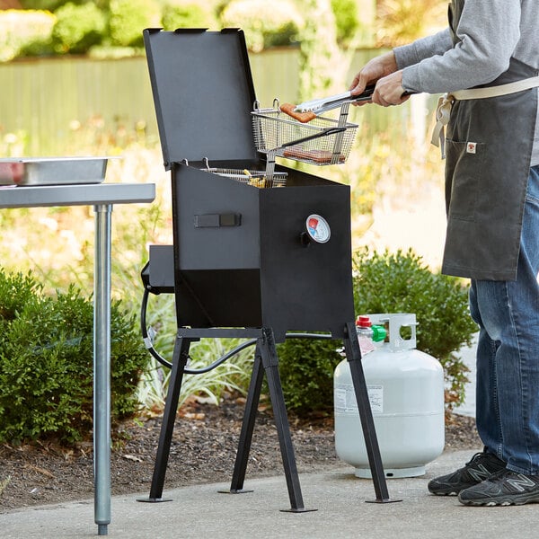 A man frying food in an outdoor fryer