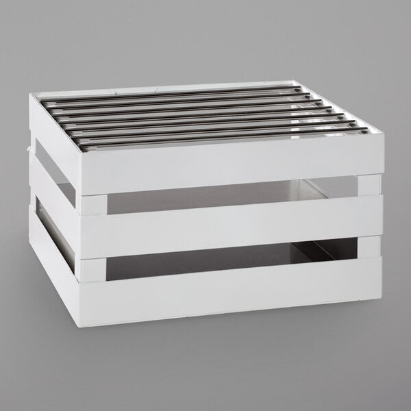 A white crate with metal slats on top.