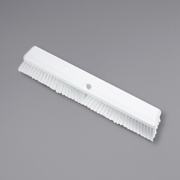 A Carlisle white push broom head with bristles.