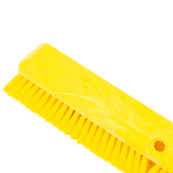 A yellow Carlisle Sparta Omni Sweep push broom head with long bristles.