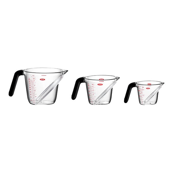 A group of clear OXO Good Grips measuring cups with handles.