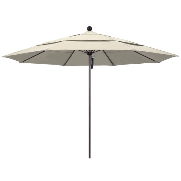 An antique beige California Umbrella with a bronze pole.