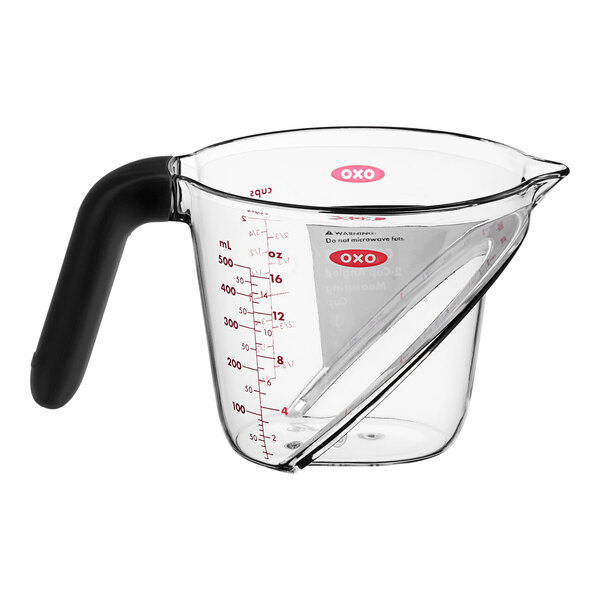 A clear plastic measuring cup with a black handle.