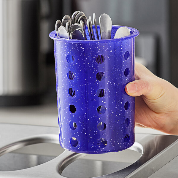 A hand holding a purple Steril-Sil flatware cylinder with silverware inside.