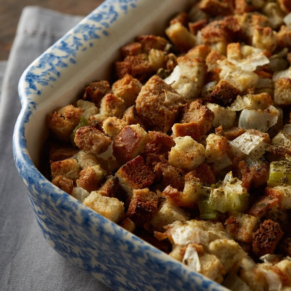 A blue and white casserole dish of stuffing with Regal Ground Sage, croutons, and onions.