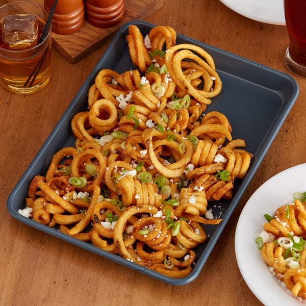 A Baker's Mark non-stick aluminum sheet pan of onion rings on a table.