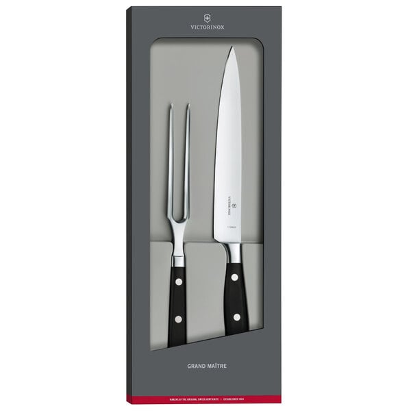 A Victorinox Grand Maitre forged knife and fork set in a box with a white rectangular logo.
