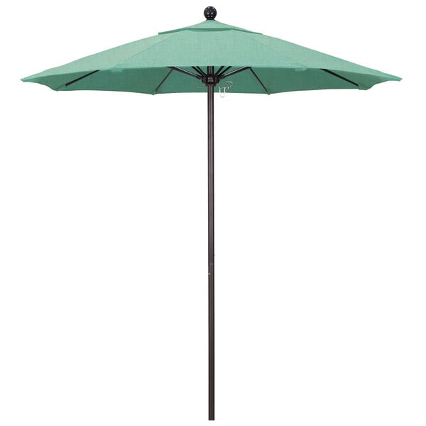 A green California Umbrella on a bronze pole.