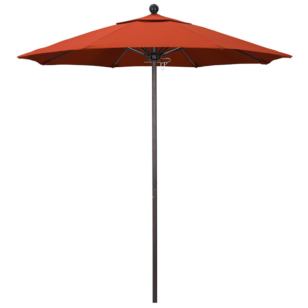 A red California Umbrella on a bronze pole.