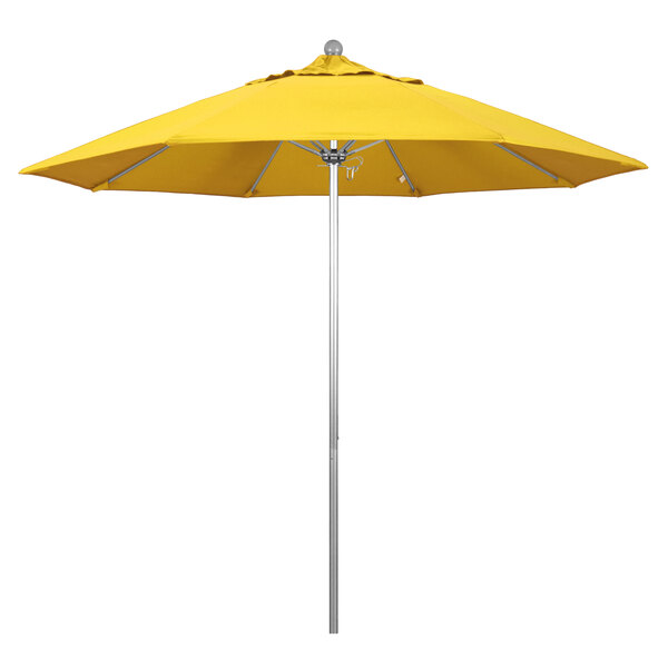 A California Umbrella with a lemon yellow canopy on a silver metal pole.