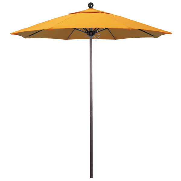 A yellow California Umbrella on a bronze pole.
