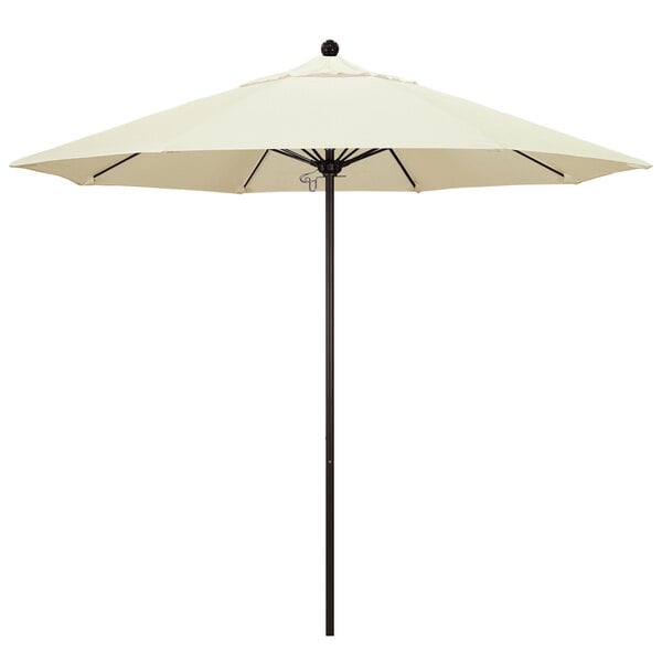 A white California Umbrella on a bronze pole.