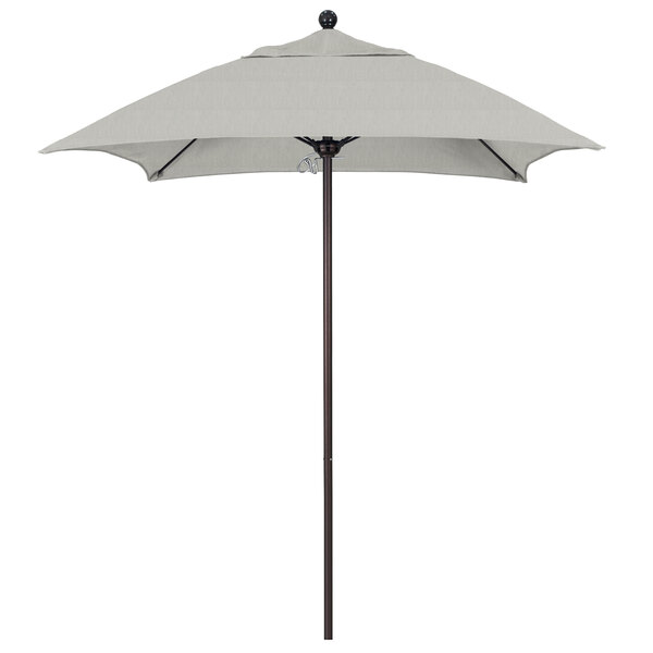 A white California Umbrella on a bronze pole.