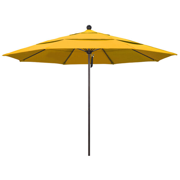 A yellow California Umbrella on a bronze pole.