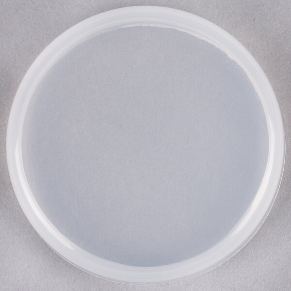 A clear plastic storage lid with white accents on a white surface.